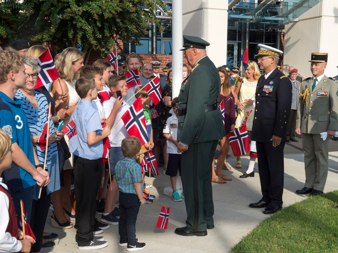 Kong Harald tok seg god tid til å helse på barna som hadde møtt fram ved hovudkvarteret. Foto: NATO